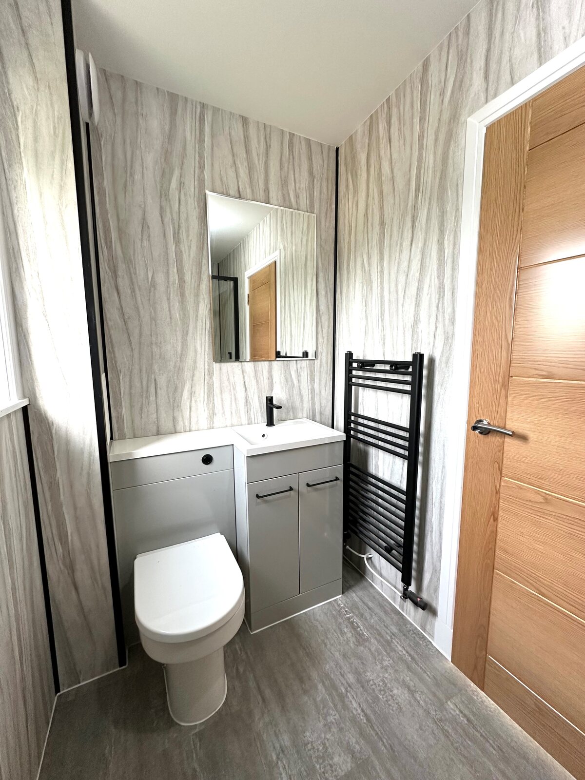 Completed ensuite with fitted vanity, black tap and black towel radiator